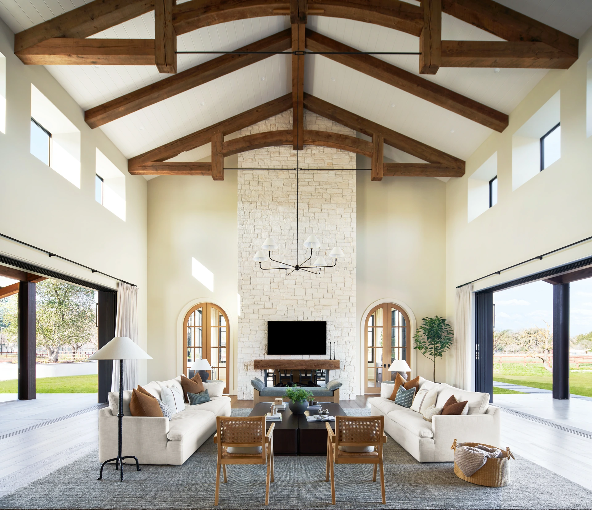 Great room of a Pleasanton custom home by Ridgecrest Designs with reclaimed wood trusses and a stone fireplace