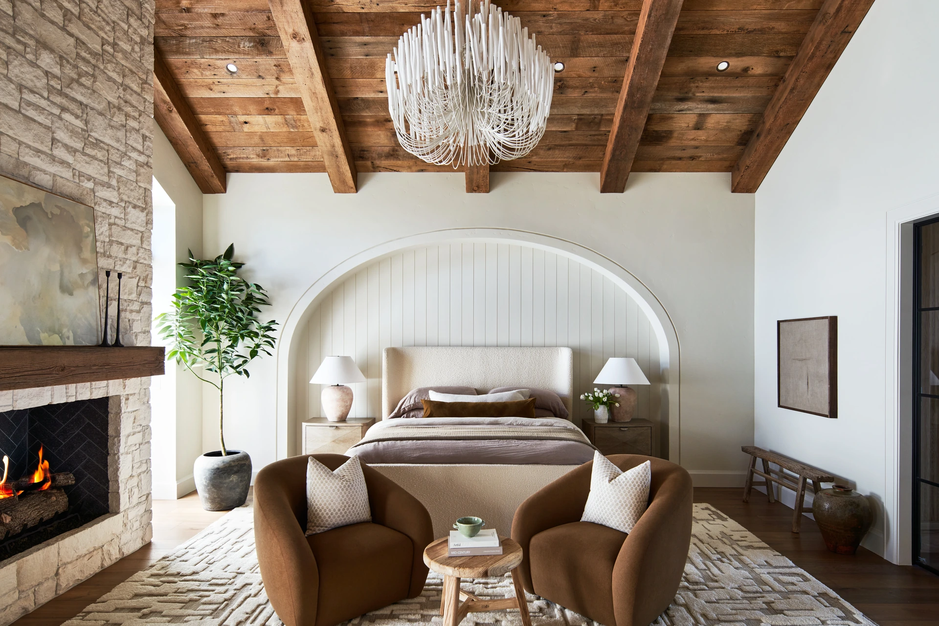 Primary bedroom of a Pleasanton custom home by Ridgecrest Designs with an Arteriors chandelier and McGee & Co bed